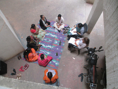 Ground-level parking is being used for social gathering at a housing project